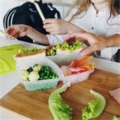 Family preparing a school lunch in reusable contianers
