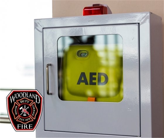 photo of wall mounted AED with Woodland Fire Department logo