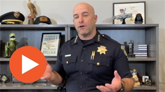 Screenshot from video with Chief Ryan Kinnan talking and a play button icon at bottom left