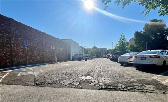 Photo of cracked pavement at the First St lot