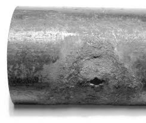 Black and white image of exterior of fire line pipe with holes from MIC bacteria