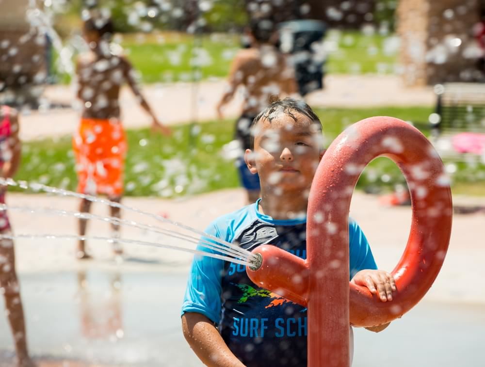 Boy Playing With Splash Pad Feature