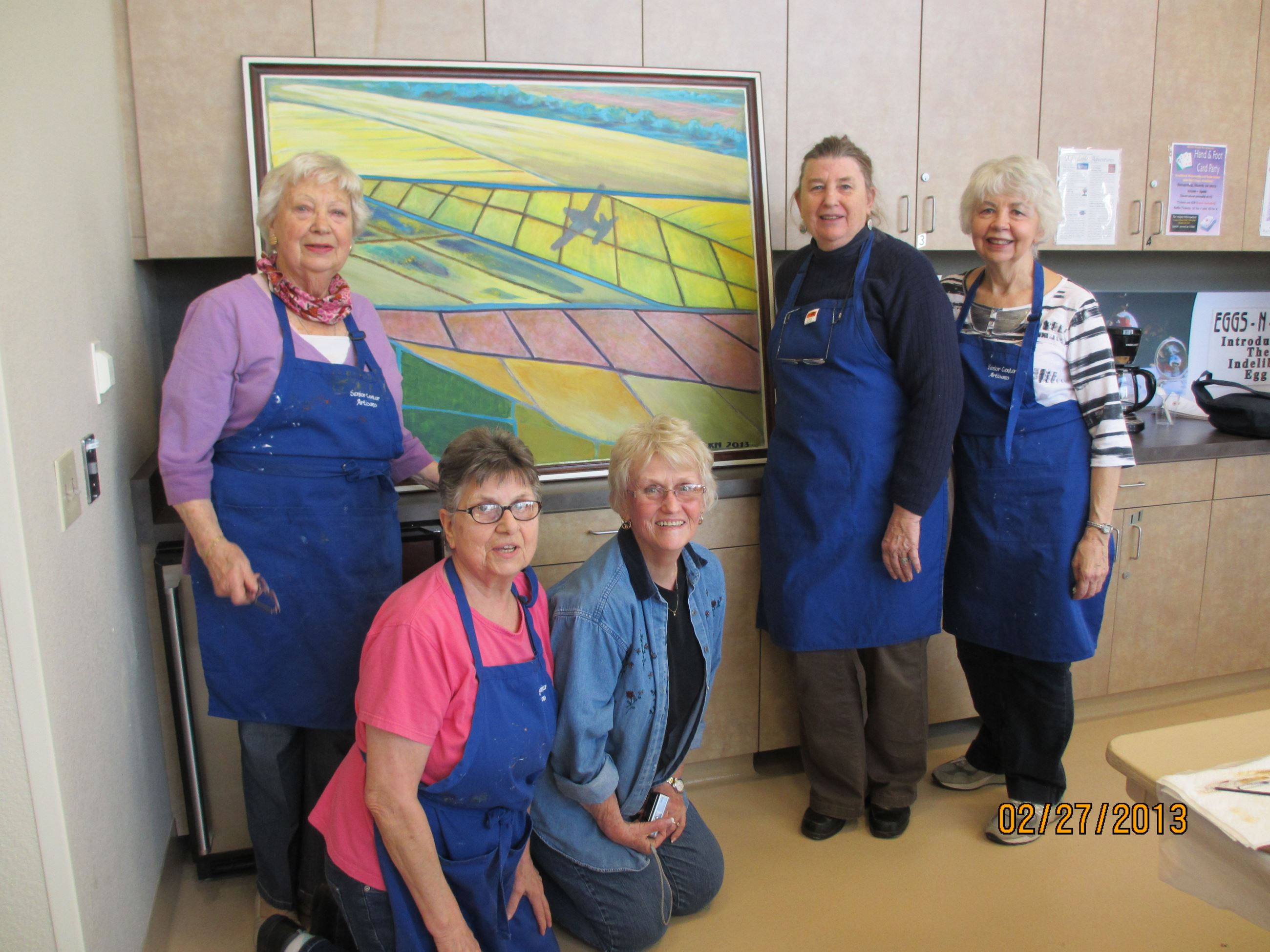 Group of people posing by painting