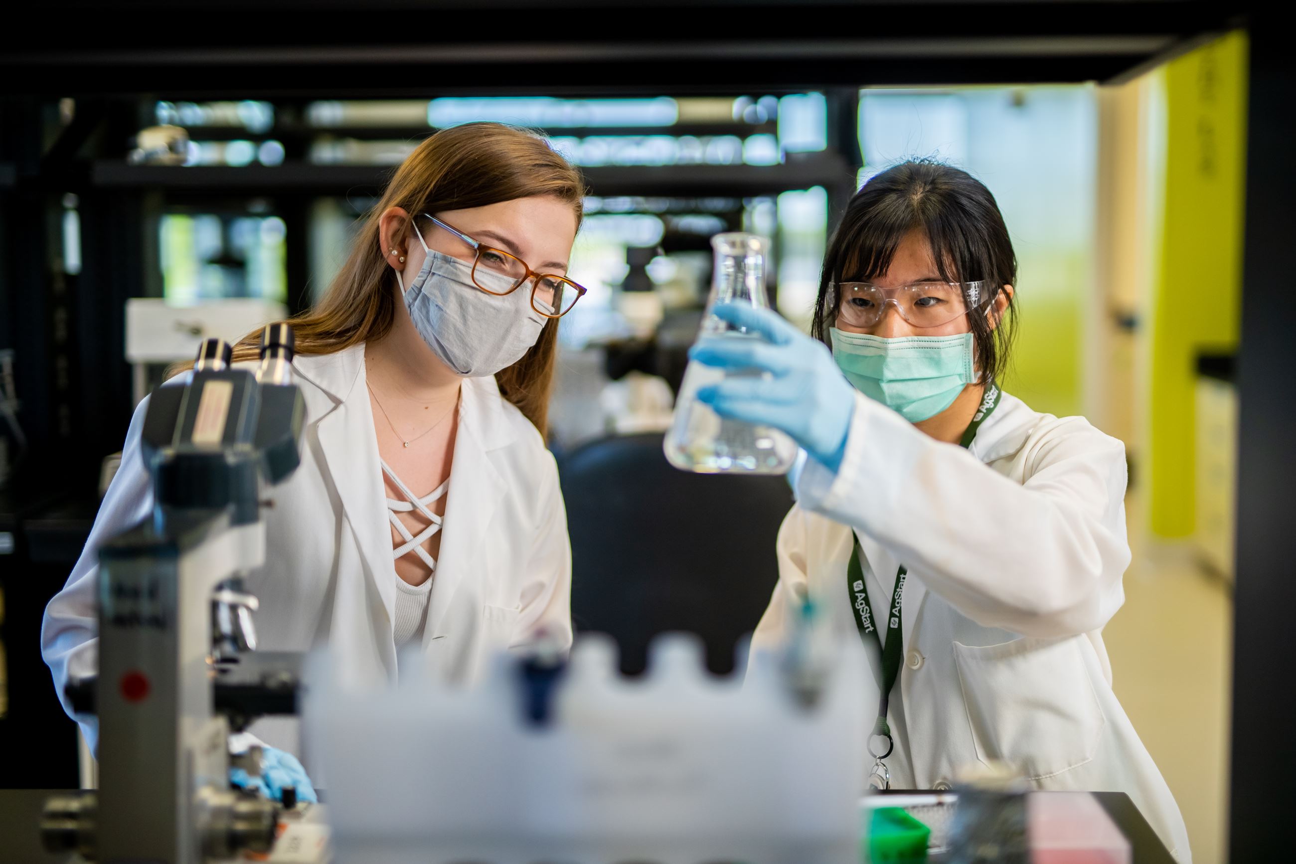 The Lab@AgStart research lab with two women examining a beaker
